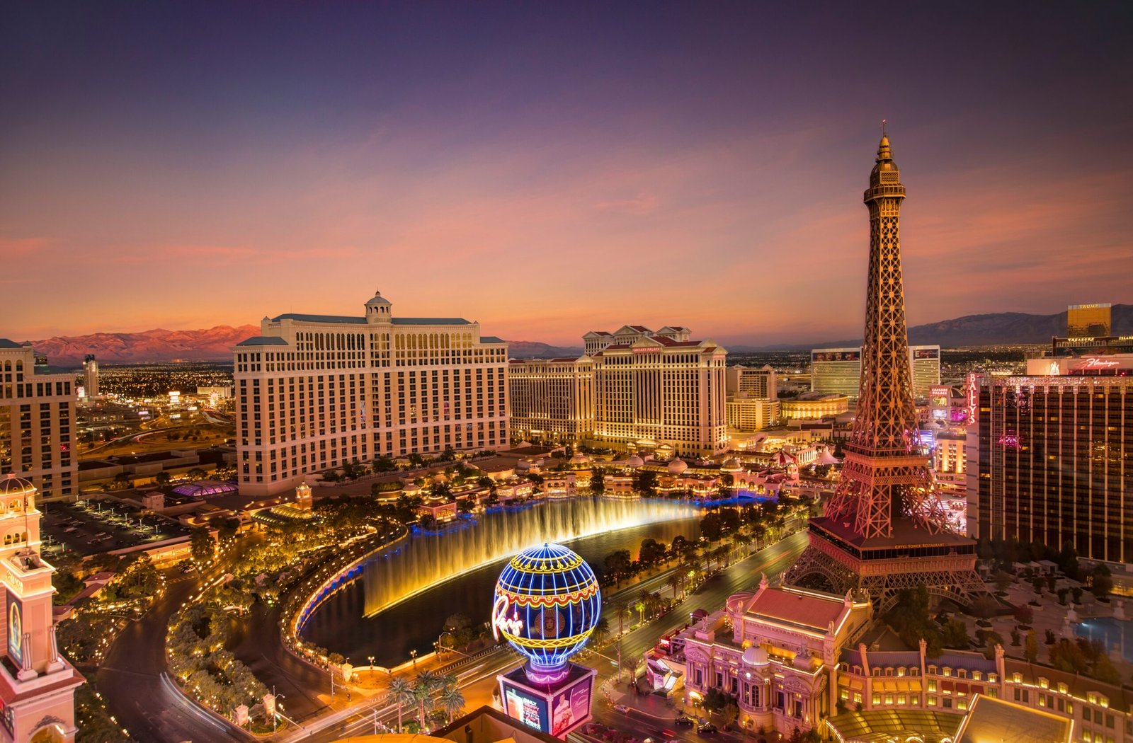 A sky view of Las Vegas at dusk, the lights blending with the colors of the sunset.
