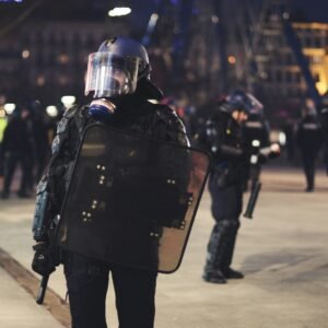 man in black uniform standing on grey concrete pavement