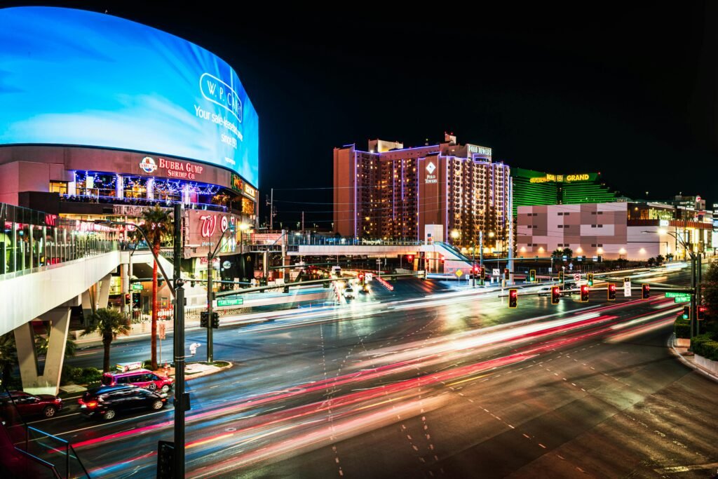 Dynamic night view of Las Vegas Boulevard featuring light trails and vibrant city lights.